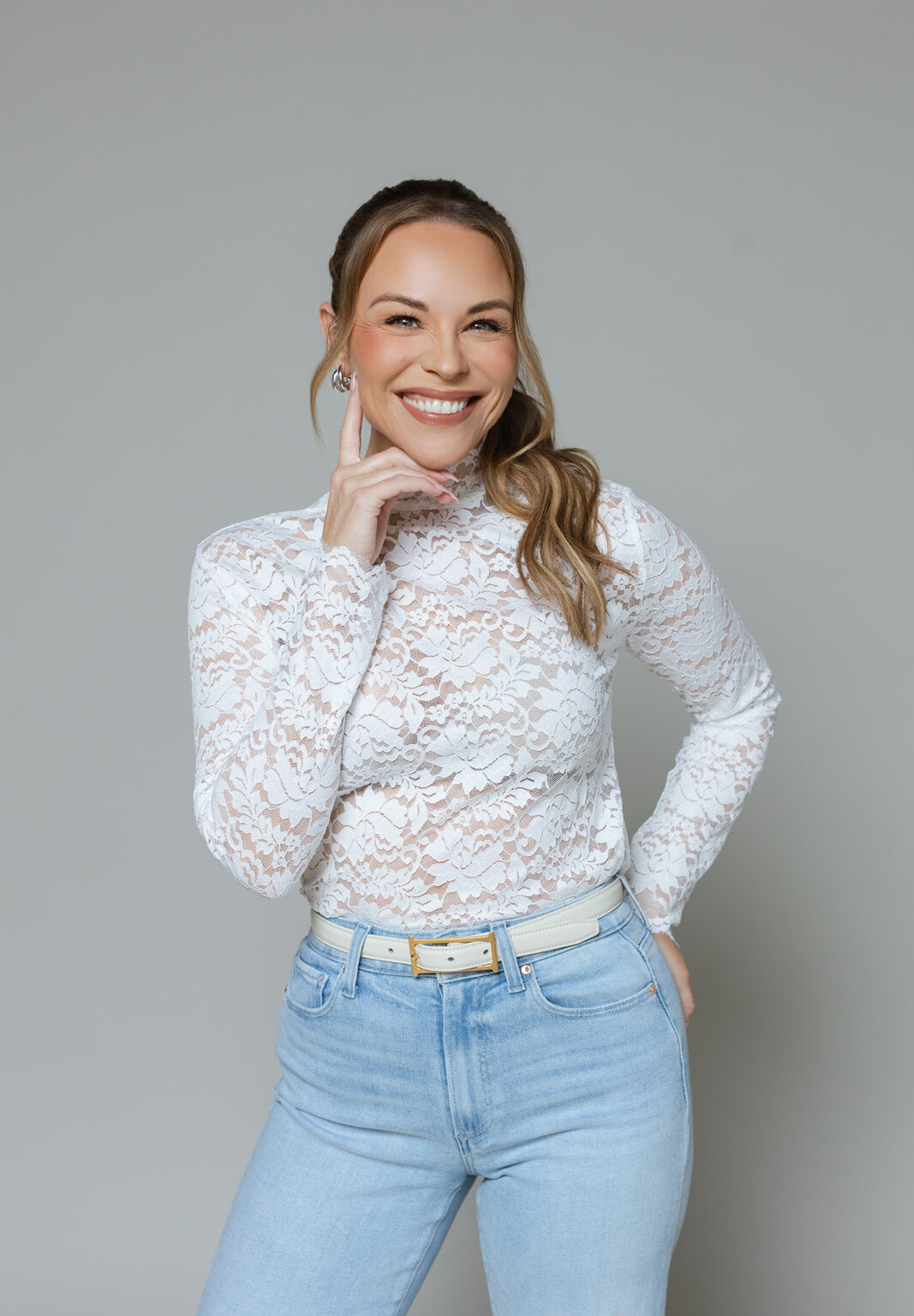 Julie Solomon in a white lace top, smiling