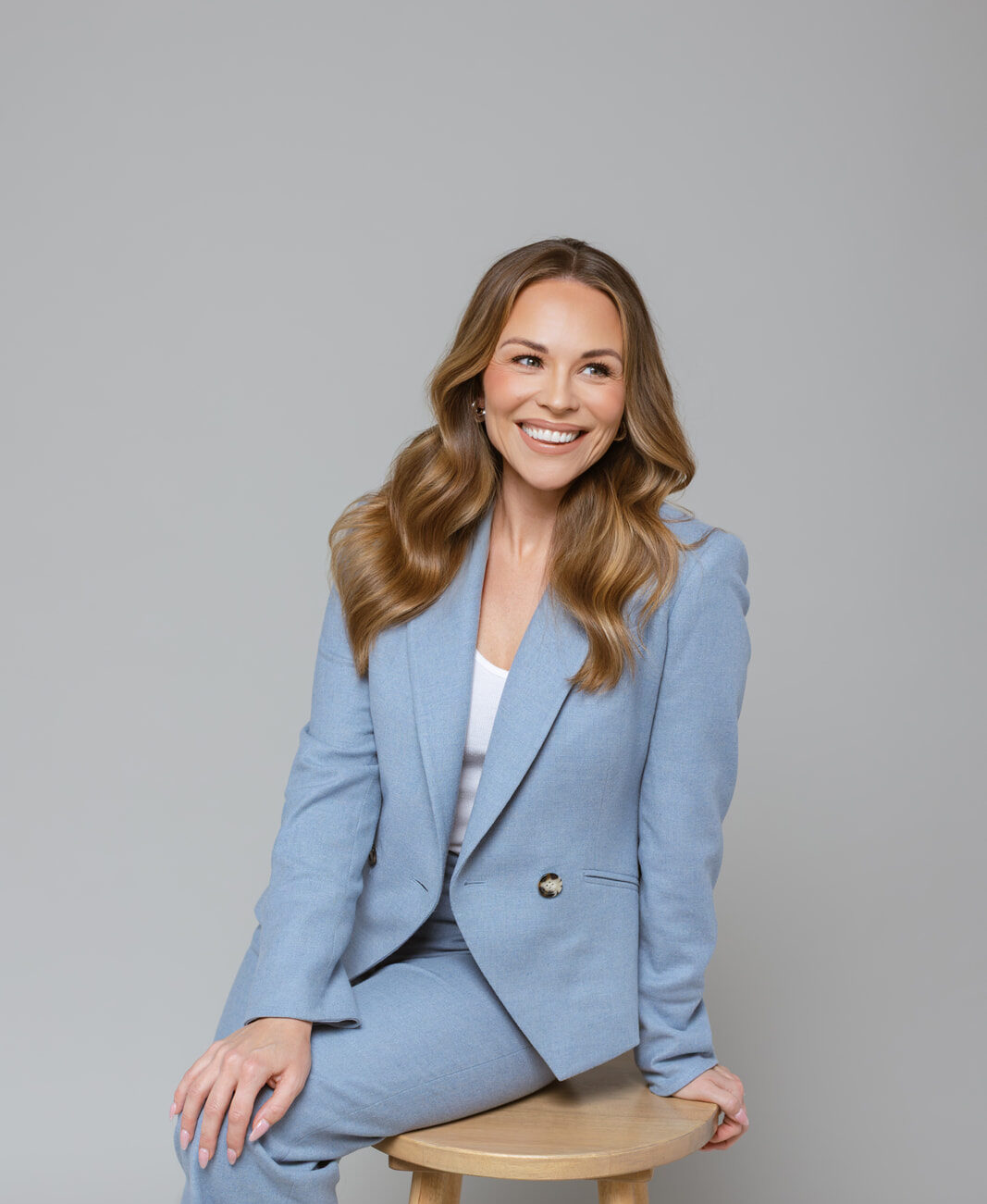 Julie Solomon seated in a blue suit, smiling